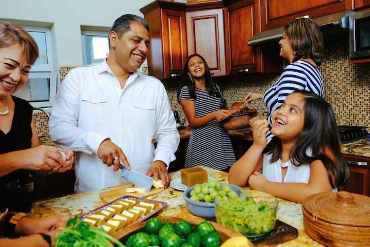 family laughing while cooking the kitchen